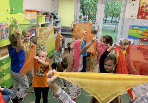 Dzieci bawią się chustami podczas Dnia Drzewa