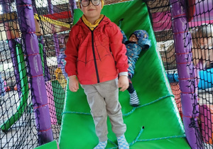 Chłopiec pozuje do zdjęcia w parku rozrywki