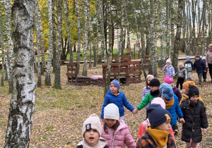 Dzieci podczas spaceru między drzewami