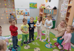 Dzieci przekazują sobie z rąk do rąk pomarańcze