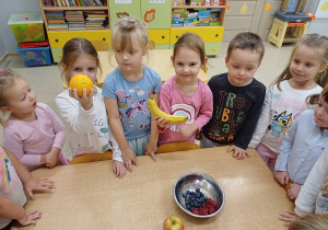 Dzieci pokazują owoce, które będą próbowały