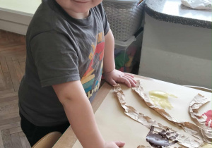 Chłopiec wykonuje pracę plastyczną