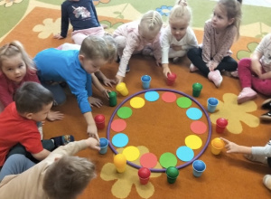 Dzieci uczestniczą w zabawie na dywanie o kolorach