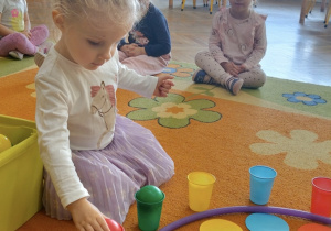 Dziewczynka uczestniczy w zabawie na dywanie