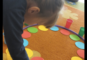 Dziewczynka uczestniczy w zabawie na dywanie