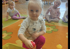 Dziewczynka uczestniczy w zabawie na dywanie