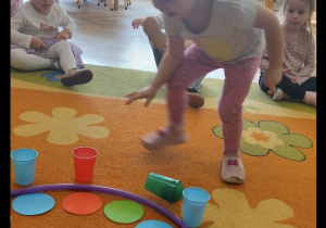 Dziewczynka uczestniczy w zabawie na dywanie