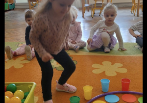 Dziewczynka uczestniczy w zabawie na dywanie