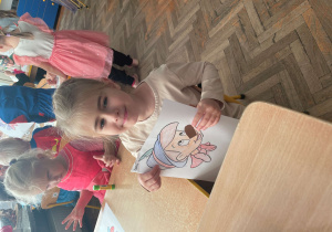 Dziewczynka pokazuje swoją pracę