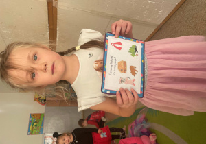 Dziewczynka pozuje z plansza do zdjęcia