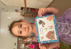 Dziewczynka pozuje z plansza do zdjęcia