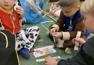 Dzieci układają puzzle na dywanie