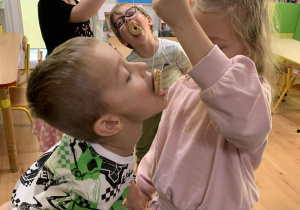 Chłopiec próbuje zjeść ciastko zawieszone na sznurku