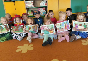 Maluchy pozują do zdjęcia z planszami z postaciami z baśni