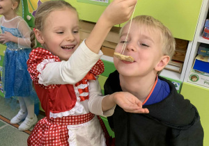 Chłopiec próbuje zjeść ciastko zawieszone na sznureczku