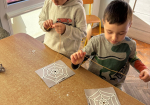 Dzieci przeplatają pajęczynę dla tarantuli