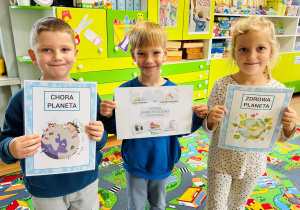 Dzieci pokazują planetę zdrową i chorą