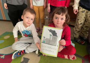 Dzieci pozują do zdjęcia z planszą tematyczną