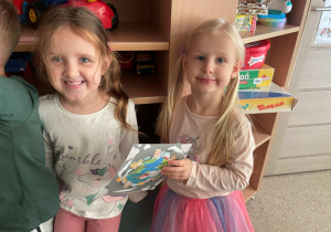 Dziewczynki pozują do zdjęcia z planszą tematyczną