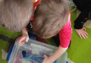 Dzieci wykonują eksperyment z wodą