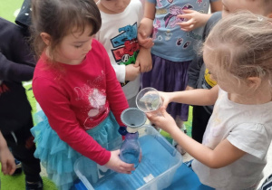 Dzieci wykonują eksperyment z wodą