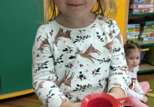 Dziewczynka pozuje do zdjęcia z lejkiem do eksperymentu