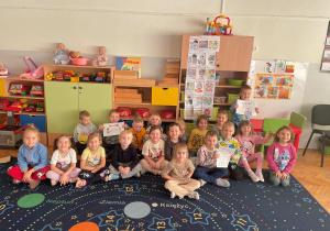 Dzieci pozują do zdjęcia ze swoim plakatem