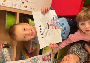 Chłopiec trzyma napis z okazji Dnia Praw Dziecka