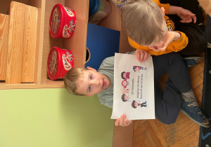 Chłopiec trzyma napis z okazji Dnia Praw Dziecka