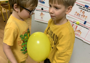 Chłopcy tańczą z balonem