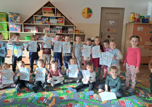 Dzieci pozują do zdjęcia z napisem z okazji Dnia Praw Dziecka
