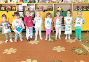 Dziewczynki pozują do zdjęcia z tablicami demonstracyjnymi