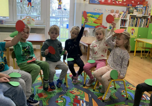 Dzieci podnoszą do góry czerwone kartki