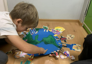 Chłopiec dokleja część swojej pracy