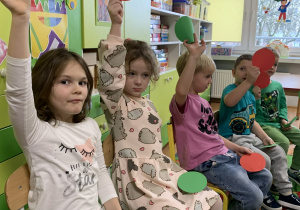 Dzieci podnoszą do góry czerwone kartki