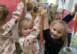 Dzieci podnoszą do góry kolorowe chustki