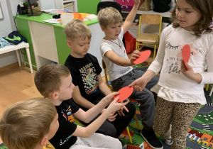 Dziewczynka rozdaje czerwone koła