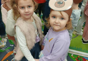 Dwie dziewczynki w opaskach tańczą przy muzyce