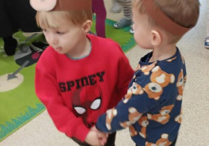 Dwóch chłopców w misiowych opaskach tańczy przy muzyce