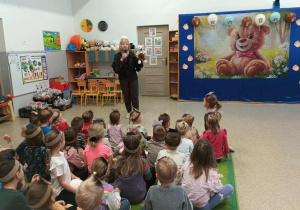 Nauczycielka z misiem wita dzieci