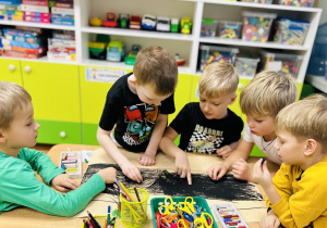 Chłopcy rysują kredkami