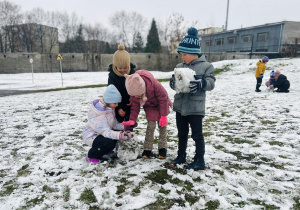 Dzieci łapią śniegowe kule