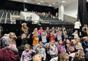 Dzieci siedzą w sali teatralnej