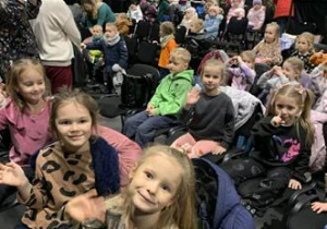 Dzieci siedzą w sali teatralnej