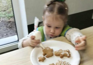 Dziewczynka dekoruje pierniki