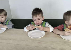 Chłopcy jedzą pizzę