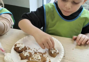 Chłopiec dekoruje pierniki