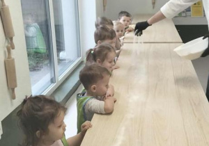 Pan Łukasz posypuje stół mąką