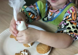 Dziewczynka dekoruje pierniki