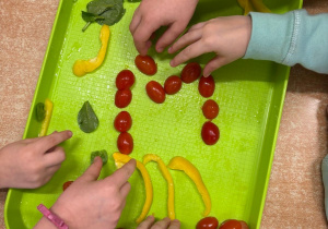 Dzieci układają literkę M z warzyw
